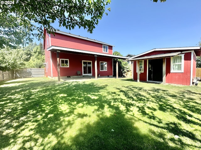 rear view of property with a patio, an outdoor structure, and a yard