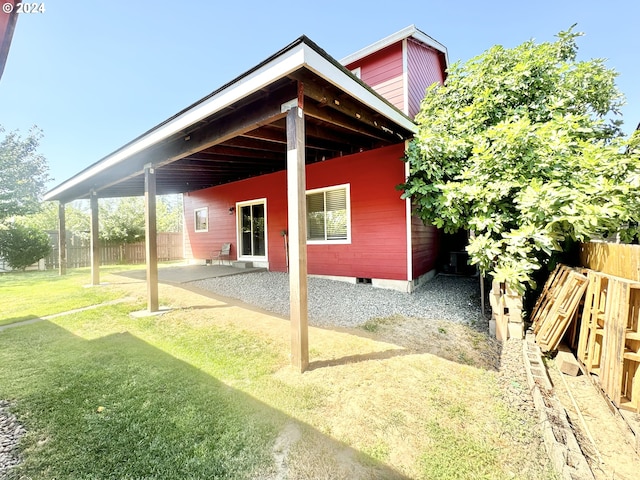 rear view of property featuring a patio area and a lawn