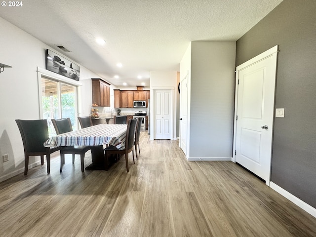 dining space featuring hardwood / wood-style flooring and a textured ceiling