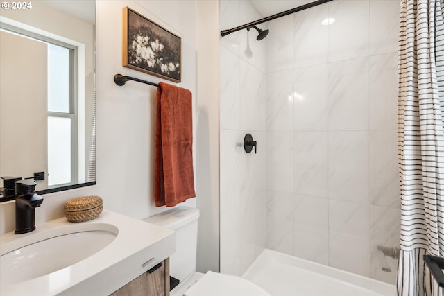 bathroom with walk in shower, toilet, and vanity with extensive cabinet space