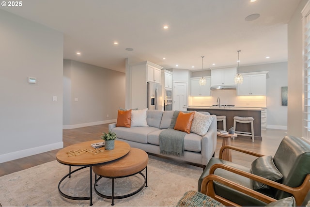 living room featuring light wood-type flooring and sink