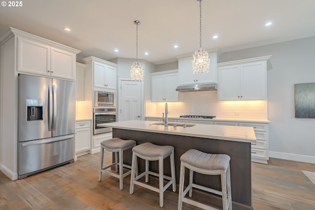 kitchen featuring sink, white cabinetry, a center island with sink, and appliances with stainless steel finishes