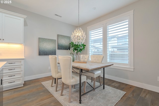 dining area featuring a notable chandelier and dark hardwood / wood-style flooring