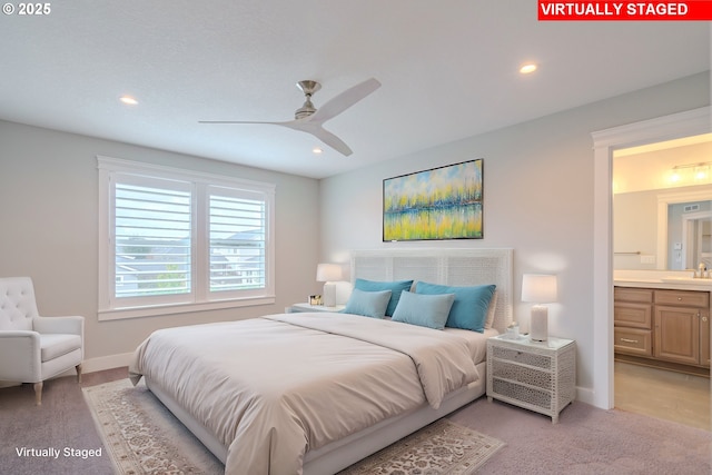 bedroom with sink, light colored carpet, connected bathroom, and ceiling fan