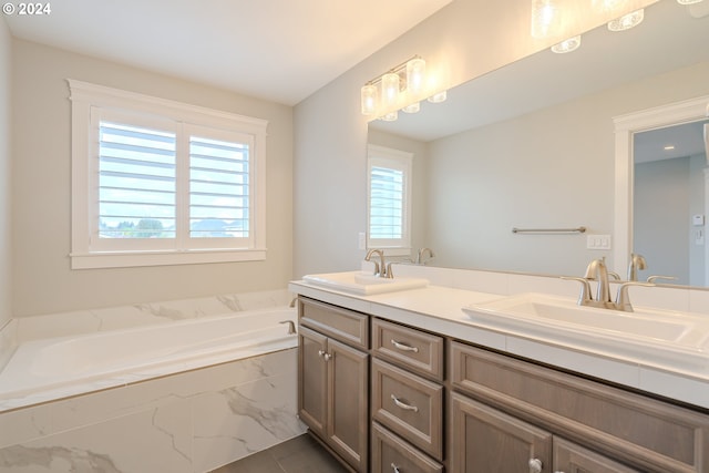 bathroom featuring a relaxing tiled tub and vanity