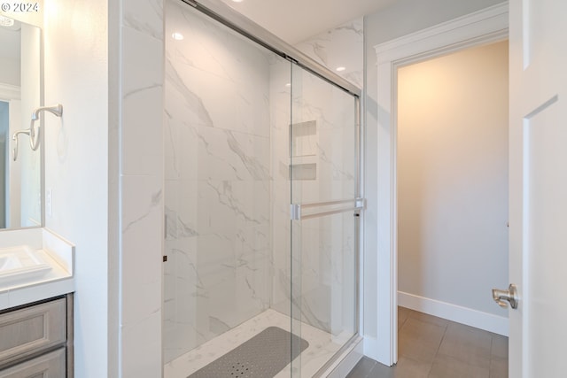 bathroom featuring tile patterned flooring, an enclosed shower, and vanity