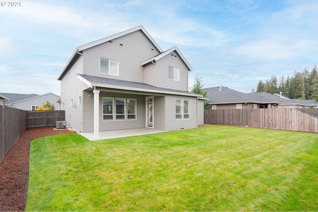 back of house with central air condition unit, a patio area, and a lawn