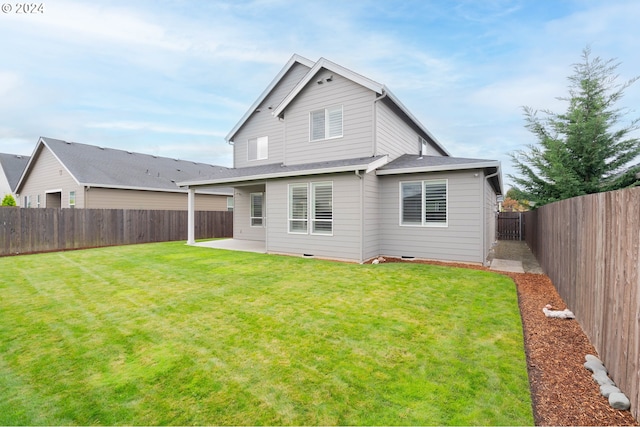 back of house featuring a patio area and a lawn