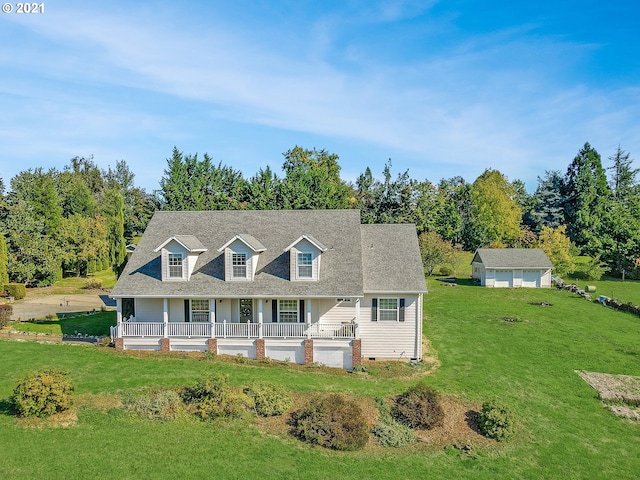 view of front of property with a porch, an outbuilding, and a front lawn