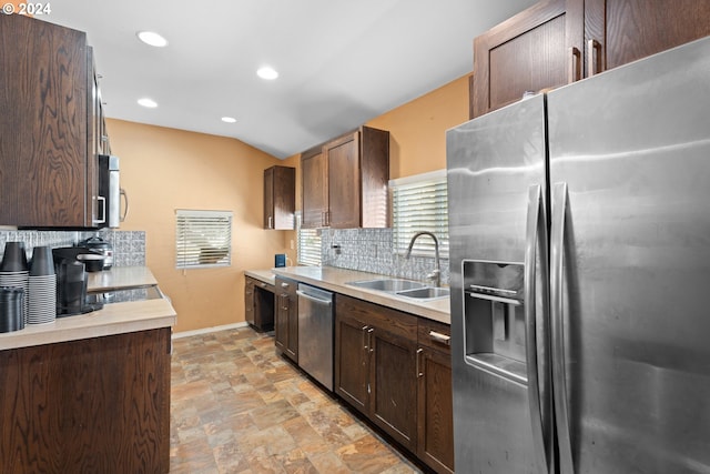 kitchen with dark brown cabinetry, stainless steel appliances, sink, and tasteful backsplash