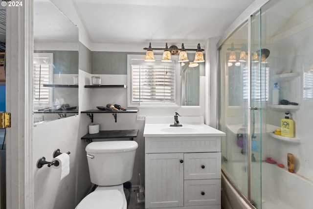 full bathroom with enclosed tub / shower combo, vanity, and toilet