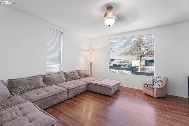 living room with dark hardwood / wood-style flooring and ceiling fan