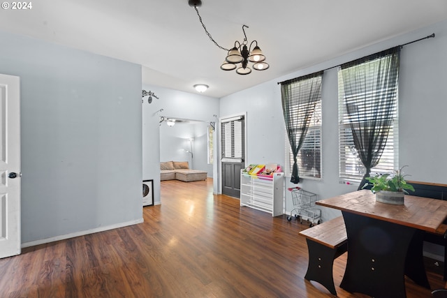 office with dark wood-type flooring and a notable chandelier