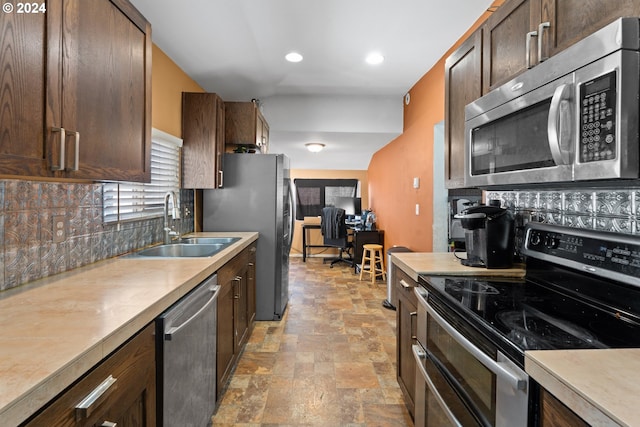 425 NW 3rd Ave, Canby, OR 97013 - kitchen featuring appliances with stainless steel finishes, a sink, backsplash, light stone finish flooring, and light countertops