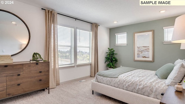 bedroom featuring light carpet, visible vents, and baseboards