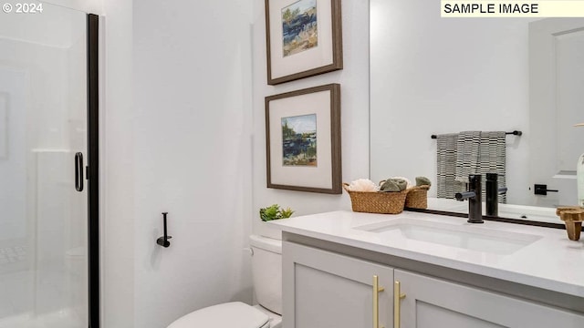 bathroom with vanity, toilet, and a shower stall