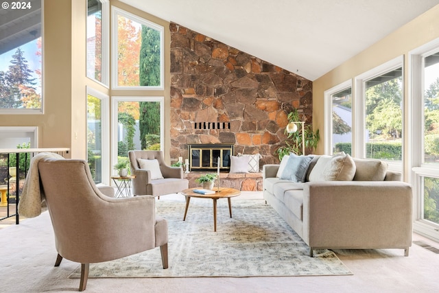 sunroom / solarium with vaulted ceiling and a stone fireplace