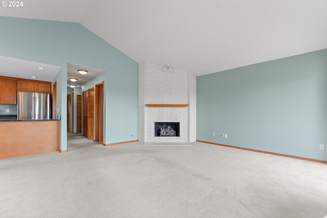 unfurnished living room featuring light carpet, high vaulted ceiling, a fireplace, and baseboards