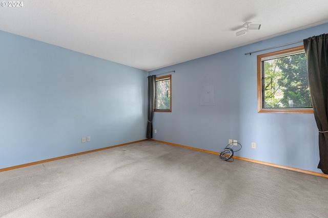 spare room featuring a textured ceiling, carpet floors, and baseboards