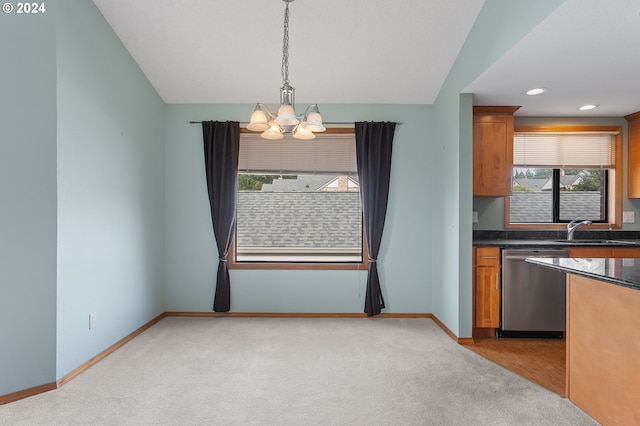 kitchen featuring brown cabinets, hanging light fixtures, stainless steel dishwasher, an inviting chandelier, and a sink