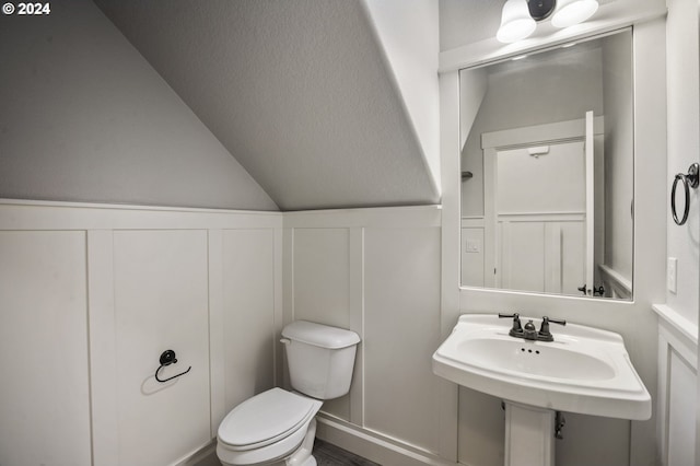 bathroom with lofted ceiling and toilet