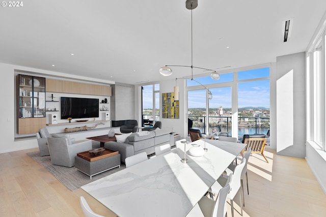 dining room featuring a chandelier, light hardwood / wood-style flooring, and expansive windows