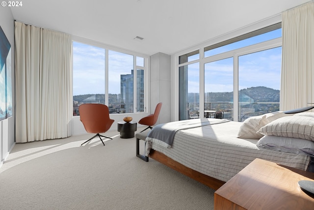 bedroom featuring expansive windows and carpet