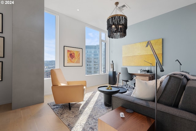 living room with light hardwood / wood-style flooring and an inviting chandelier