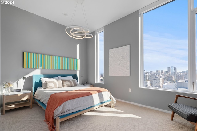 bedroom with multiple windows, a chandelier, and carpet