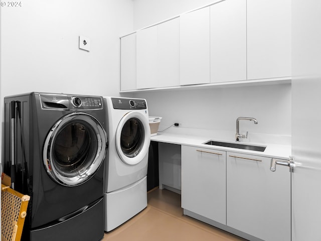 clothes washing area featuring cabinets, independent washer and dryer, and sink