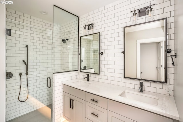 bathroom with a shower with door, vanity, tile walls, and decorative backsplash