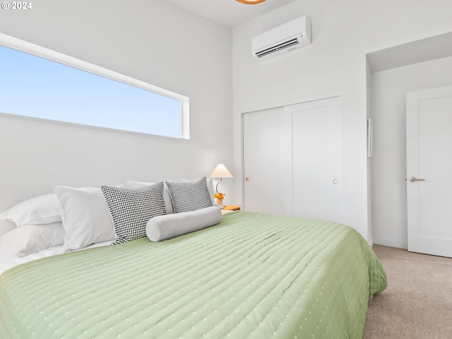 bedroom with light colored carpet, a closet, and a wall unit AC