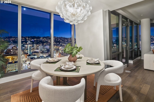 dining area featuring an inviting chandelier, floor to ceiling windows, and wood finished floors