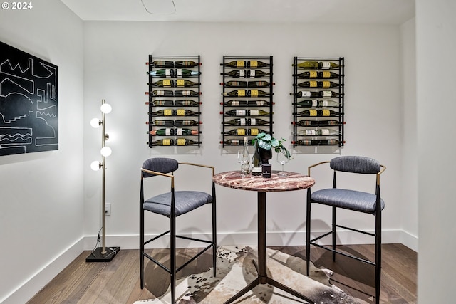 wine area featuring baseboards and wood finished floors