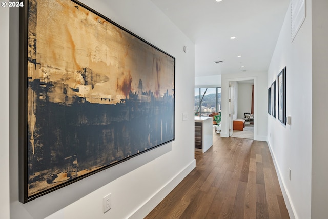 hall with visible vents, recessed lighting, hardwood / wood-style flooring, and baseboards