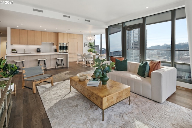 living room with light wood-style floors, a wealth of natural light, and visible vents