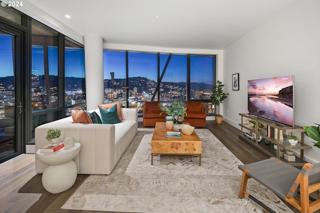 living area with a wall of windows, wood finished floors, and baseboards