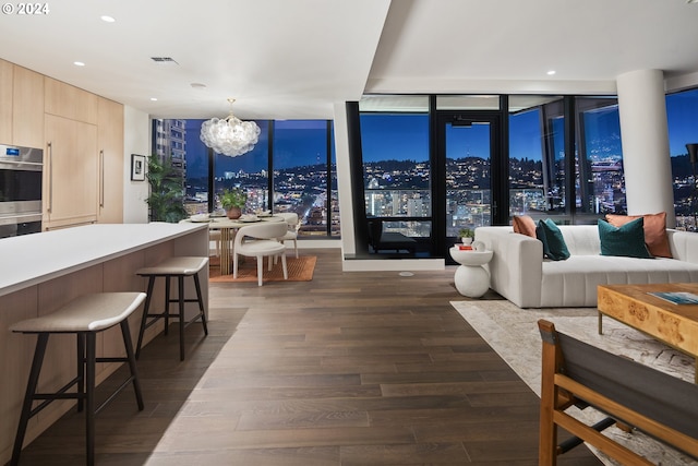 living room with dark wood-style flooring, recessed lighting, visible vents, and a notable chandelier