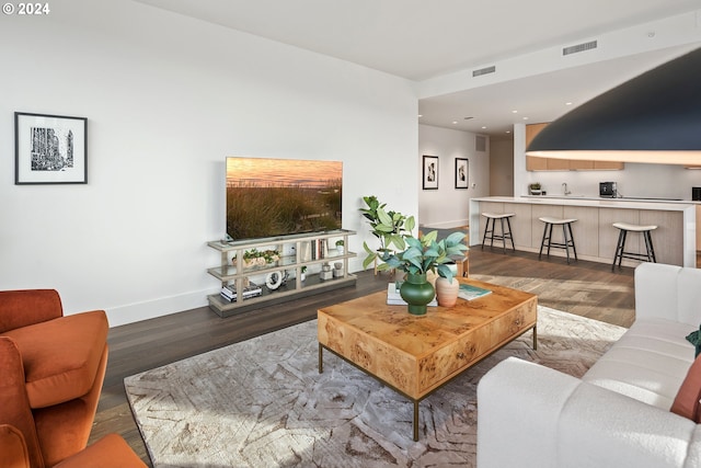 living area featuring wood finished floors, visible vents, and baseboards