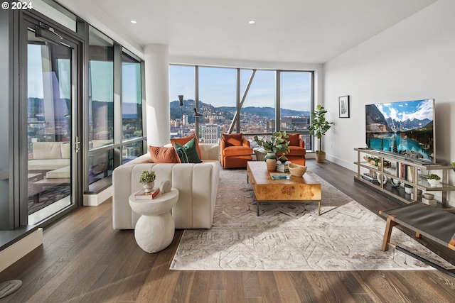 living area with baseboards, a wall of windows, and wood finished floors