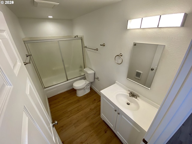 full bathroom featuring enclosed tub / shower combo, toilet, wood-type flooring, and vanity