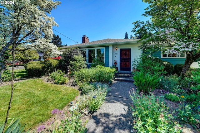 view of front of house featuring a chimney and a front yard