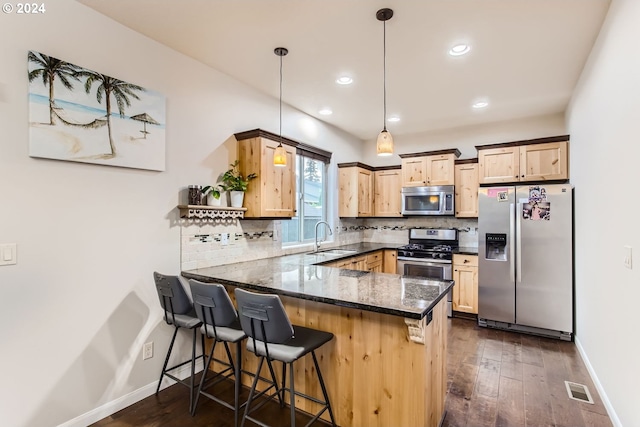 kitchen with sink, stainless steel appliances, hanging light fixtures, and kitchen peninsula