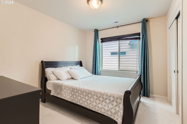 bedroom featuring a closet and light colored carpet