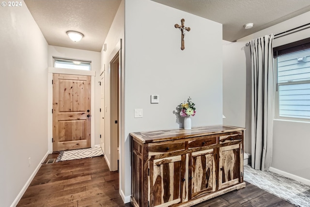 interior space with a textured ceiling and dark hardwood / wood-style floors