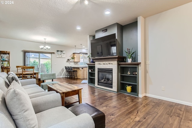 living room with an inviting chandelier, a textured ceiling, and hardwood / wood-style floors