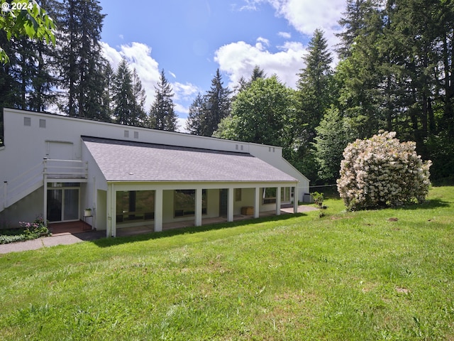 rear view of property featuring a lawn