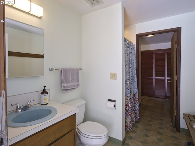 bathroom with tile patterned flooring, vanity, and toilet