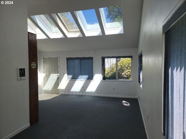 carpeted spare room featuring vaulted ceiling