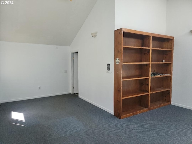 carpeted empty room with lofted ceiling